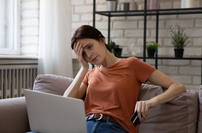 stressed woman with laptop and card